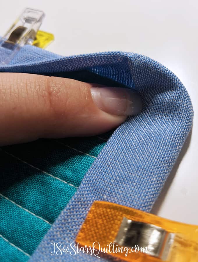 A step by step tutorial with a video and photos to show you how to create a mitered corner in your quilt binding! Don't get frustrated, I can show you how.