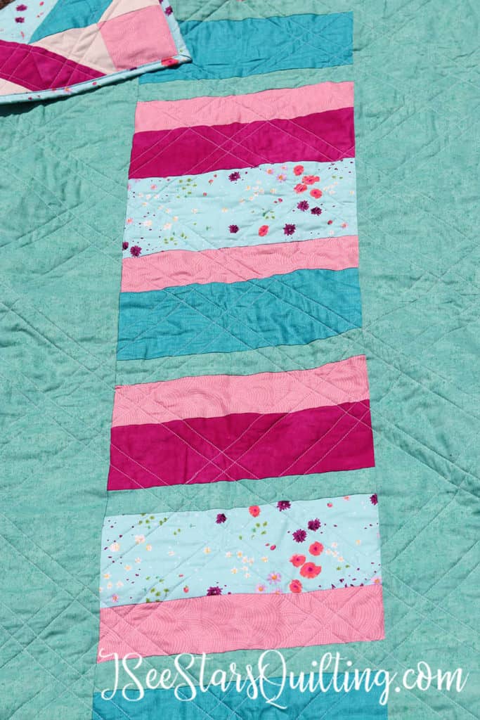 This is an example of a quilt back I created where instead of creating a normal seam of 2 same fabrics together, I added a column of striped fabric to the back of my quilt for added interest.